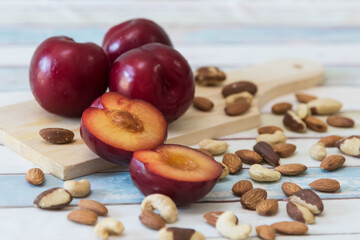 plums and mixed nuts on a wooden table