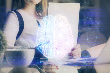Multi exposure of woman's writing hand on background with brain hud. Concept of learning.