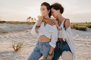 cute two young women having fun on the sunset beach, queer non-binary gender identity, gay lesbian...