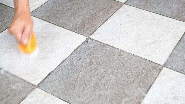 Men's hands are used to convert polishing cleaning on the tile floor.