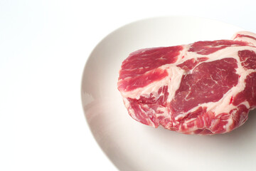 豚肩ロースのブロックと白い皿