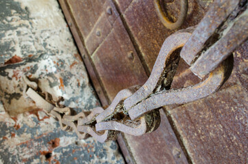 Old rusty chain and massive wrought iron doors
