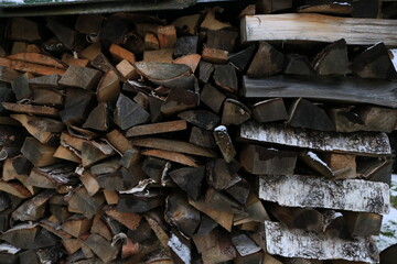 Pile of firewood background. Winter countryside village stack of wood. Logs for fire. Natural forest material timber.