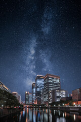 Stars of the milky way over office buildings in a city