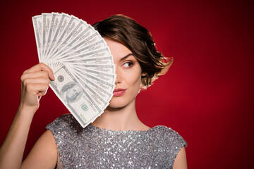 Closeup photo of attractive lady casino club professional player hold fan bucks winner look tricky cunning side wear shine grey dress isolated burgundy gradient dark red color background