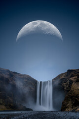 A huge moon over Skogafoss waterfall in Iceland