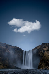 A single cloud over Skogafoss waterfall in Iceland
