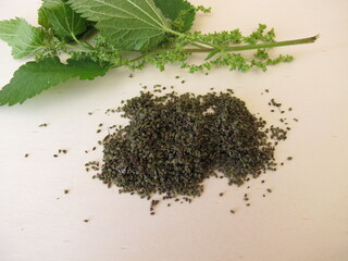 Nettle and dried nettle seeds on a wooden board