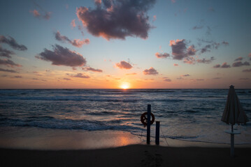 
sunset on the shore with objects for the rescue of bathers
