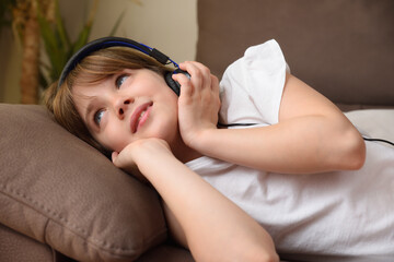 Obraz na płótnie Canvas Detail of girl listening to music carefully lying on sofa