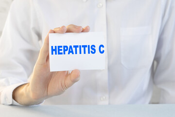 Doctor holding a card with text HEPATITIS C, medical concept