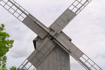 Old vintage wooden windmill in the background of the cloudy sky. Saaremaa, Estonia.