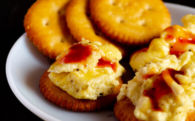 Salty biscutis with topping of cheese ,fluffy eggs and ketchup.