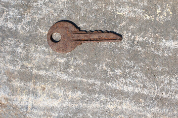 One old rusty key on a gray background. Stay at home concept. Abandoned, forgotten concept