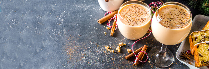 Traditional Christmas egg dairy drink with spices, in different glasses. Eggnog cocktail, Cola de mono, Crème de Vie (Cream of Life) beverage. Dark background with Christmas decor