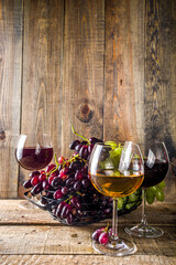 Glasses with wine. Red and white wine in glasses with grape on wooden background copy space