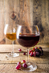 Glasses with wine. Red and white wine in glasses with grape on wooden background copy space