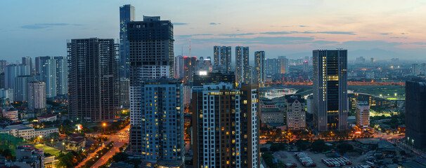 Fototapeta premium Cityscape of Hanoi skyline in Cau Giay district by Cau Giay park during sunset time in Hanoi city, Vietnam