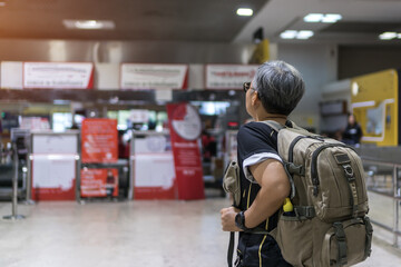 Fototapeta na wymiar Covid-19 pandemic impact to Traveler was cancel flight for stop prevent COVID-19 virus disease, state quarantine concept, Asian senior woman tourist backpack in empty airport to avoid world lockdown
