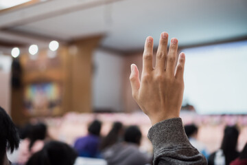 Audience or students raising hands up at conference to answer question while speaker speech at...