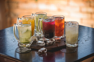 lemon, strawberry, kiwi, passion fruit caipirinhas, with ice spread over rustic table