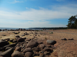 Nice view: sandy seashore, stones, horizon and blue sky