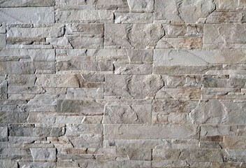 Stone cladding wall made of  stacked slabs and blocks of natural gray rocks 