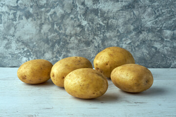 Fresh raw potatoes on textured background