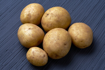 Fresh raw potatoes on textured background