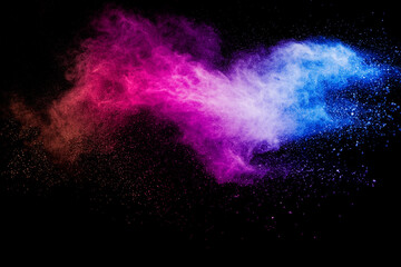 Launched multicolored powder on black background.Color powder explosion.Colorful dust splashing.