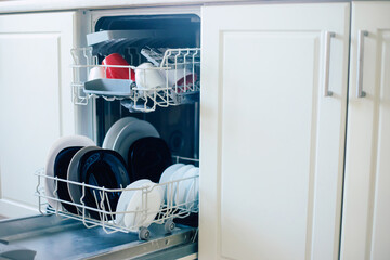 Photo of different flatware in dishwasher after work in the domestic kitchen