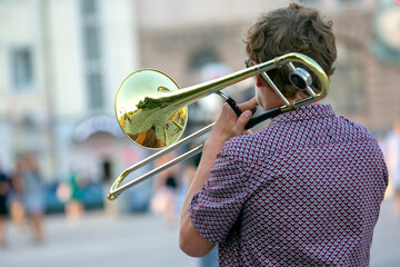 Reflection of the street in the instrument solo trumpet. male musician plays the trombone. music...