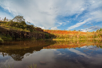 Reflexive lake with blue sky, clouds and green vegetation