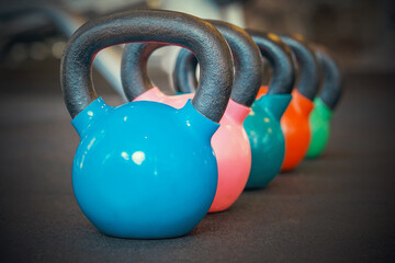 Naklejka na ściany i meble Colorful kettlebells in a row in a gym.