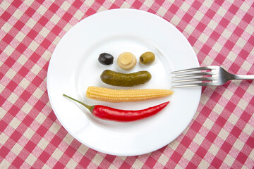 Olives, pickled cucumber, pepper, mushrooms and corn in a salad on a plate. food and vegetables. diet and weight loss