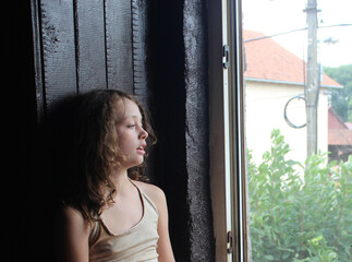 young woman looking through window