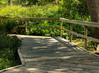 A wooden bridge walkway over a small stream in Spring, TX.