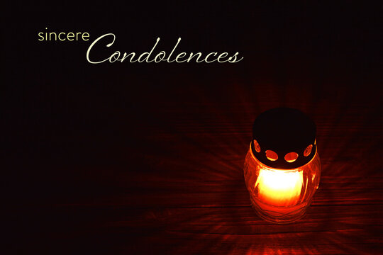 Condolence card with votive candle on dark background
