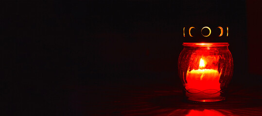 All Saints Day candle. Red votive candle on dark background - obrazy, fototapety, plakaty