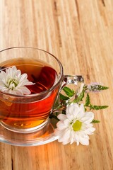 Hot drink with flowers on wooden table