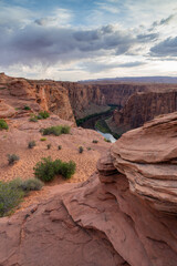 Vertical view of Glen Canyon and the Colorado River in Page, Arizona, with low clouds on a sunny day