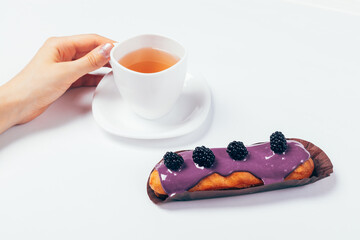 Tasty eclair cake with icing and blackberries