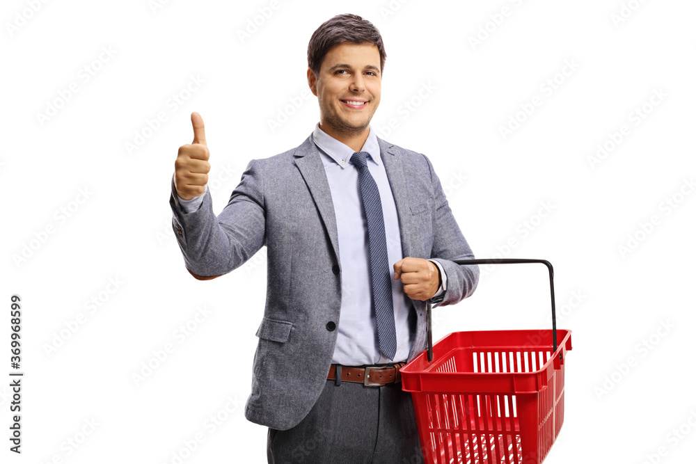 Wall mural young professional man with a red shopping basket showing thumbs up and smiling at the camera