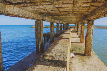 pier on the beach. old shell rock pier in the sea