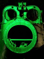 Broken off tail end of disused abandoned Helicopter grounded at night with green lighting to show controls wiring and component parts 