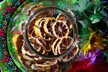 oriental painted plate with transparent vase with dried lemons