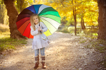 Obraz premium Cute little girle with umbrella in autumn park.