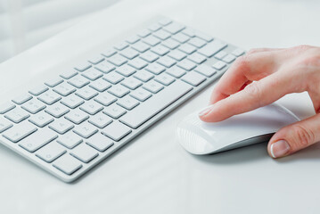 Closeup of hand using computer mouse. Closeup of businesswoman hand using computer mouse with laptop keyboard in the background