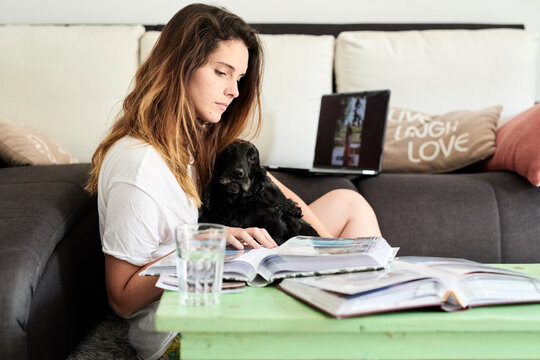 Beauty with her dog looking at photo album.