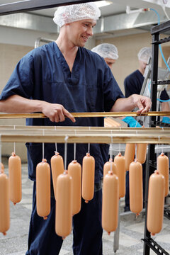 Meat Plant Worker Hanging Sausages
